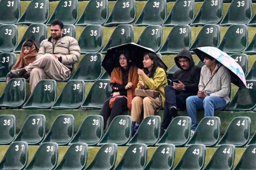 Spectators wait in the rain in Rawalpindi