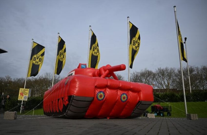 An inflated mockup of a tank in front of Borussia Dortmund flags as part of a protest agai