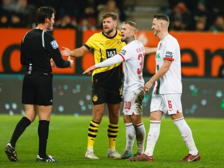 Dortmund forward Niclas Fuellkrug talks with referee Matthias Joellenbeck during his side's 1-1 draw at Augsburg on Saturday