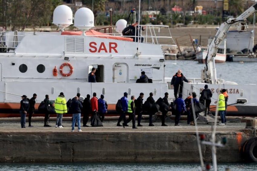 Migrants embark on an Italian coast guard ship in Albania after judges in Rome referred a