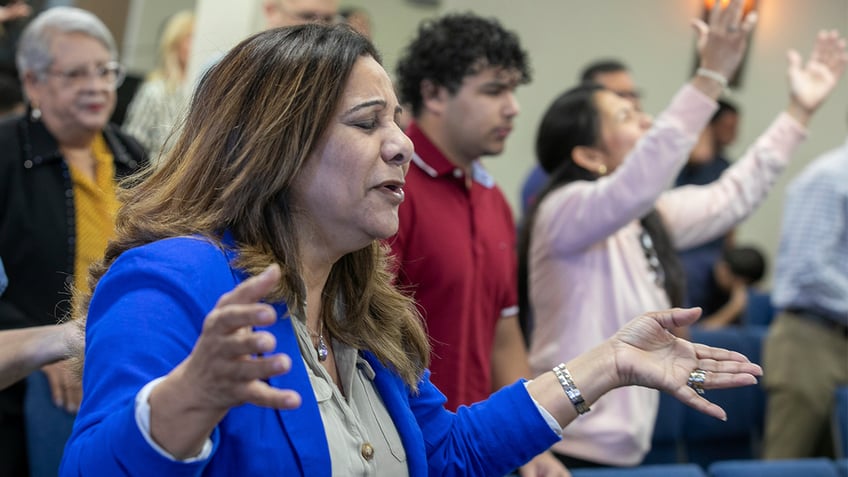 Fatima Guzman prays during a church service