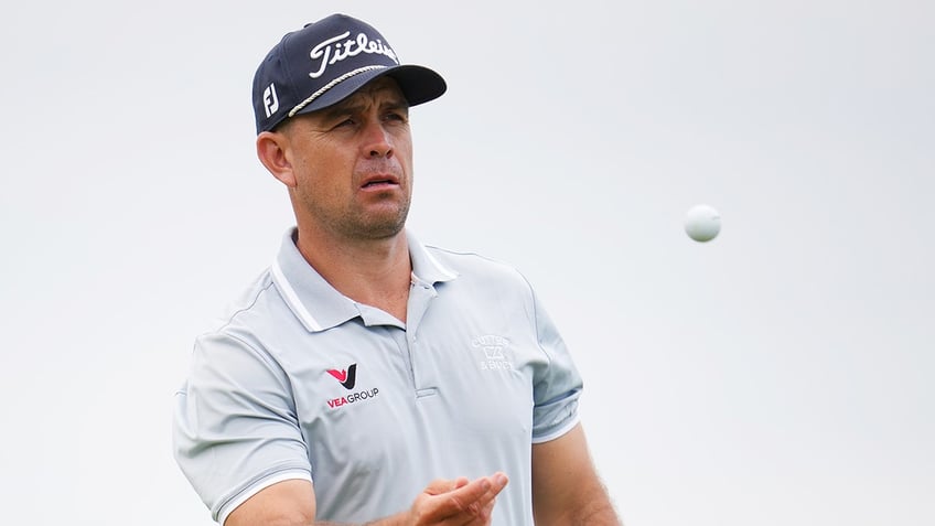 Louis de Jager tosses a golf ball