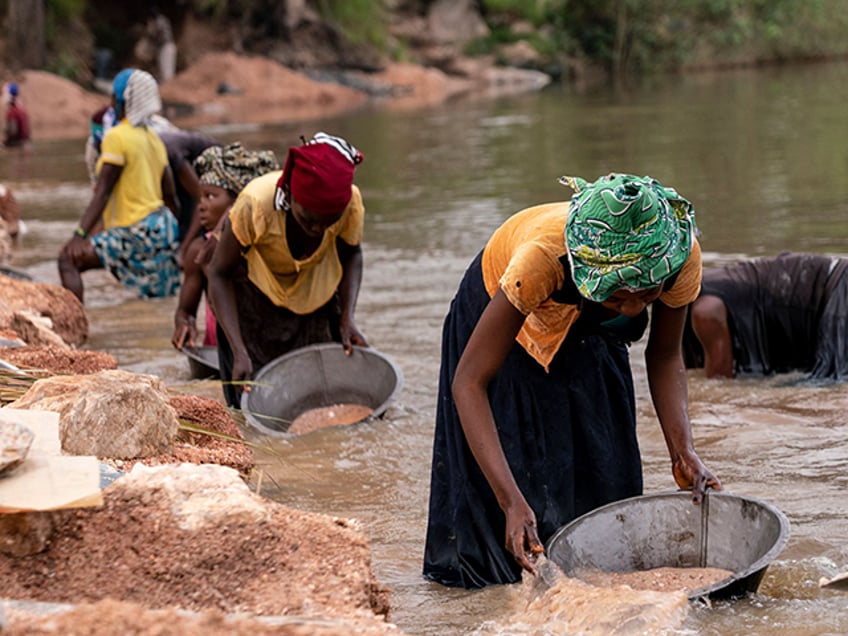 Artisanal miners collect gravel from the Lukushi river searching for cassiterite on February 17, 2022 in Manono. - The Democratic Republic of Congo is rich with Lithium, an essential mineral for electric car batteries, which nests in the remains of the former mining town of the city of Manono in the south-east of the country in the province of Tanganyika. To get out of poverty, the inhabitants of Manono, most of whom are artisanal diggers, place their hope in the investment of the Australian company AVZ minerals which plans to invest 600 million dollars in the construction of a lithium mining (Photo by Junior KANNAH / AFP) (Photo by JUNIOR KANNAH/AFP via Getty Images)