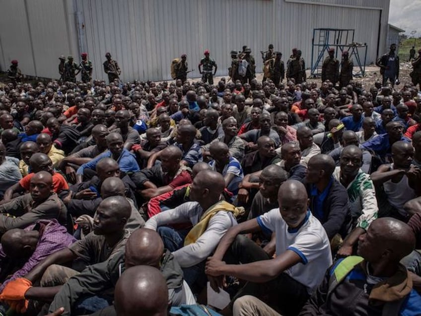 Hundreds of volunteers sit at Goma International Airport before boarding a plane that will take them to a training center after responding to Democratic Republic of Congo's President Felix Tshisekedi's call to join the army to go to the front lines to fight against the M23 rebellion (March 23 Movement) in Goma, Democratic Republic of Congo, on November 14, 2022. (Photo by Guerchom Ndebo / AFP) (Photo by GUERCHOM NDEBO/AFP via Getty Images)