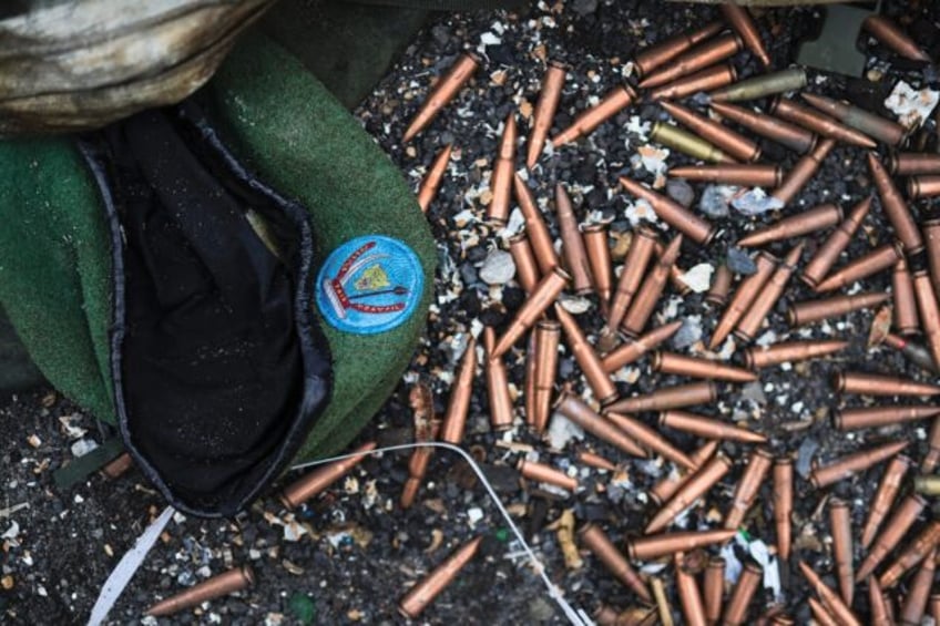 A crumpled Congolese army beret alongside cartridges near an abandoned, bullet-riddled mil