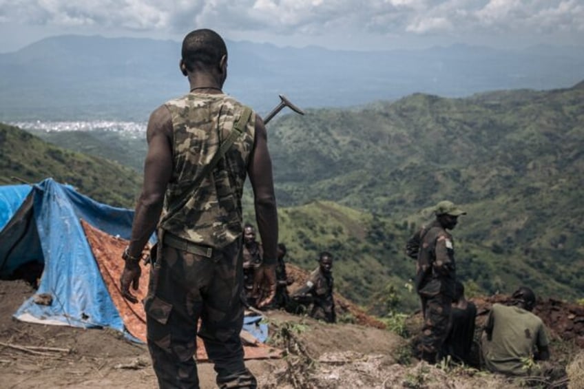 DRC soldiers dig trenches at a frontline military position above the town of Kibirizi, con