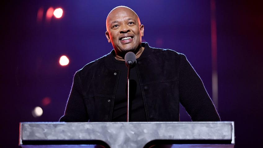 Dr. Dre looks up behind a stone podium at the Rock & Roll Hall of Fame Induction Ceremony