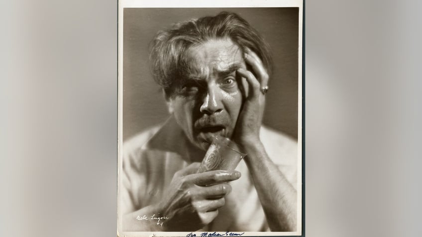 Bela Lugosi holding onto a cup and posing for a dramatic portrait.