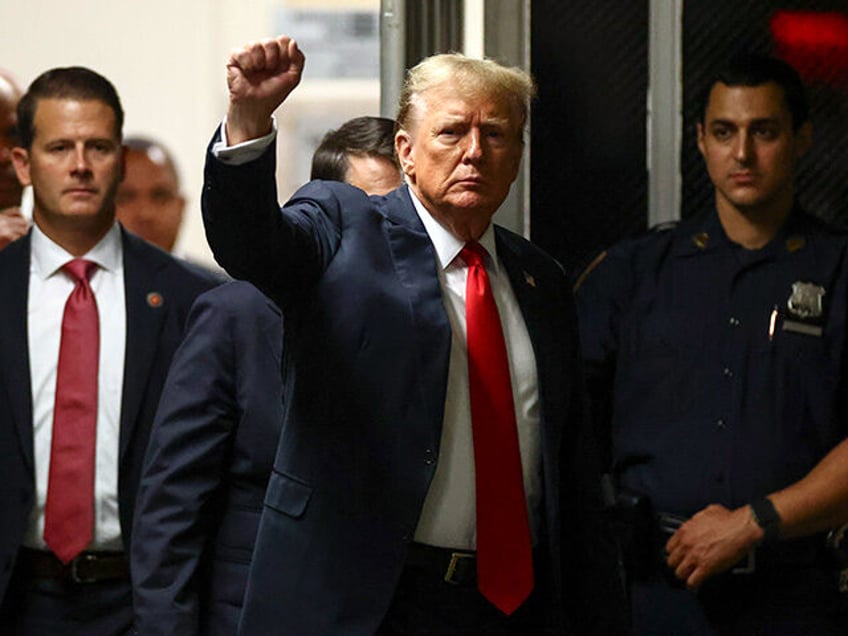 Former President Donald Trump reacts to reporters as he returns following a break at Manha