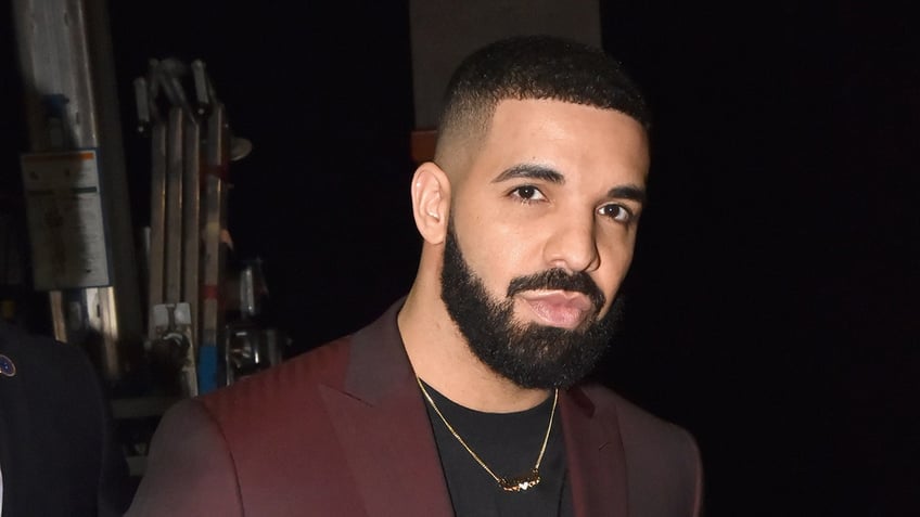 Rapper drake wears a red suit at awards show.