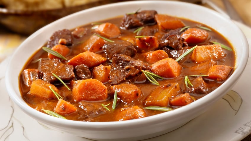 Irish stew with beef and carrots in a white bowl.