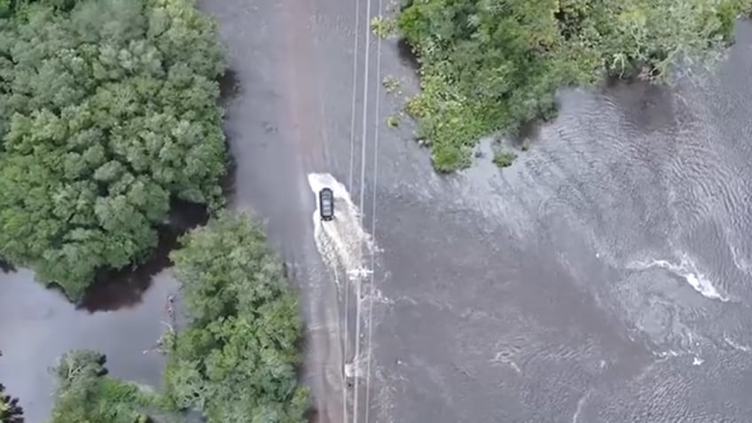 Driver moving through flooded road in Florida