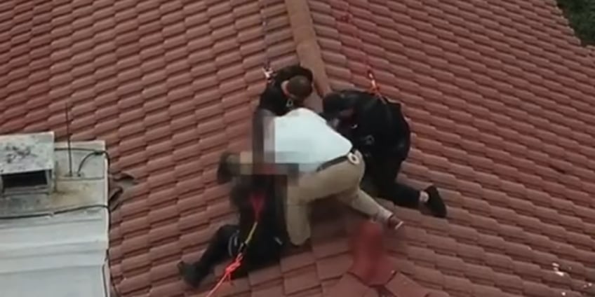 drone video shows officer scaling house to arrest suspected female intruder perched on roof