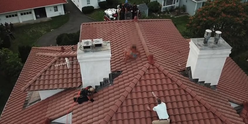 drone video shows officer scaling house to arrest suspected female intruder perched on roof