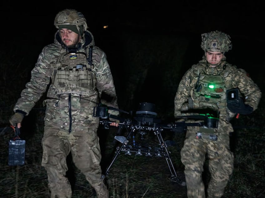 BAKHMUT DISTRICT, UKRAINE - NOVEMBER 12: A Ukrainian military man equips and prepares a drone for flight and prepares ammunition at positions 4 kilometers from the frontline as the special unit "Achilles" is preparing to carry out a combat mission at night on the heavy drone "Vampire", which the Russians call "Baba Yaga" on November 12, 2023 in the Bakhmut District, Ukraine. SkyFall, a Ukrainian company, has launched mass production of unmanned aerial vehicles. The new "Vampire" model can carry up to 15 kg of ammunition. The Armed Forces of Ukraine use Vampire hexacopters to drop different types of munitions on the enemy, such as cumulative and thermobaric, and are most often used against tanks and other armored vehicles. Unmanned aerial vehicles are equipped with a thermal imager, which allows you to attack the enemy in the dark. Ukrainian forces continue to fight to retake Bakhmut, which was captured by Russian forces in May, following a yearlong war battle. Over the summer, Ukraine regained territory north and south of Bakhmut but Russia has held the city itself. (Photo by Kostya Liberov/Libkos via Getty Images)