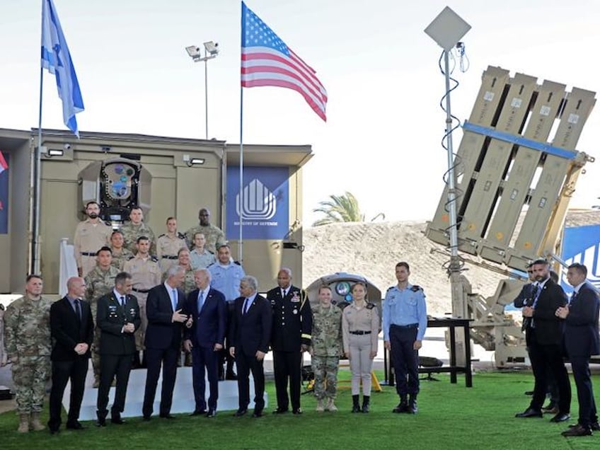 US President Joe Biden (6- L) listens to Israeli Defence Minister Benny Gantz (5- L), as they tour Israel's missile defence systems Iron Beam (L) and Iron Dome (R) at Ben Gurion Airport near Tel Aviv on July 13, 2022, with caretaker Prime Minister Yair Lapid (5- R), Israeli expert on technology and innovation Daniel Gold (4- L), Israeli army Chief of Staff Aviv Kohavi (5- L) and US Defence Attache in Israel, Brigadier General Shawn A. Harris (4nd R). (Photo by GIL COHEN-MAGEN / POOL / AFP) (Photo by GIL COHEN-MAGEN/POOL/AFP via Getty Images)