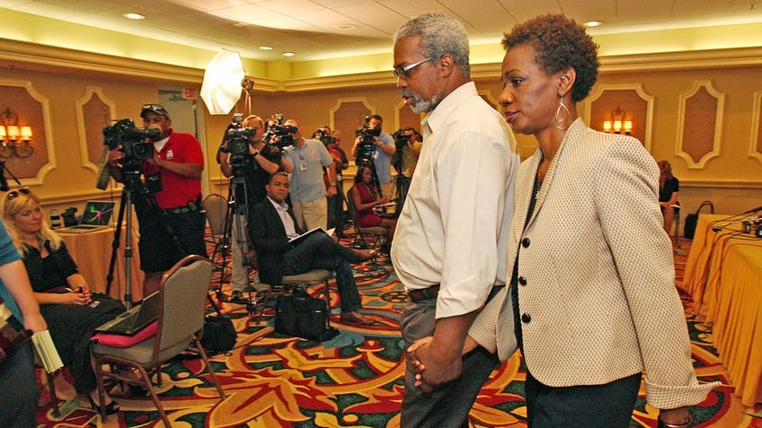 Pam Champion and Robert Champion Sr. walking toward a group of press