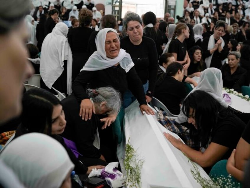 Members of the Druze minority mourn during the funeral of their relatives at the village o