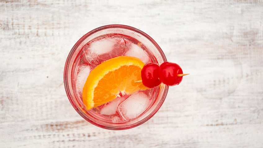 top view of a Shirley Temple cocktail glass on an aged white wooden table.