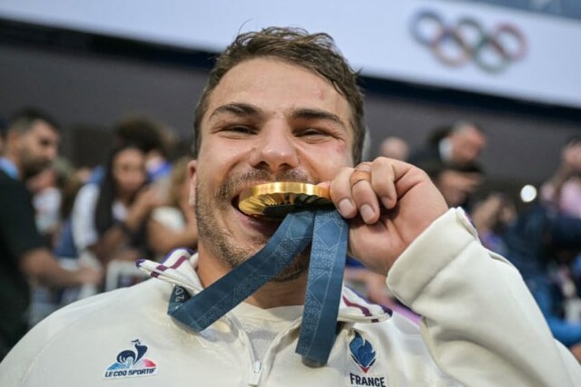 Antoine Dupont celebrates with his gold medal in July