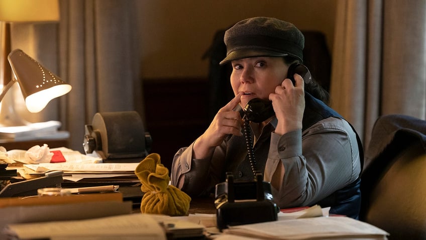 Alex Borstein in a writer's cap holds up the phone in "The Marvelous Mrs. Maisel"