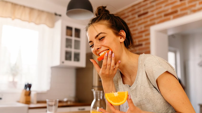 Woman eating an orange