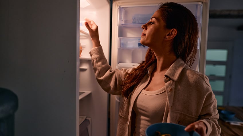 Woman looking in fridge for food