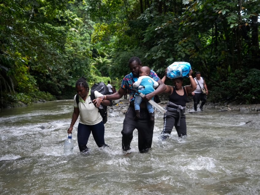 FILE - Haitian migrants wade through a river as they cross the Darien Gap, from Colombia into Panama, hoping to reach the U.S., Oct. 15, 2022. (AP Photo/Fernando Vergara, File)