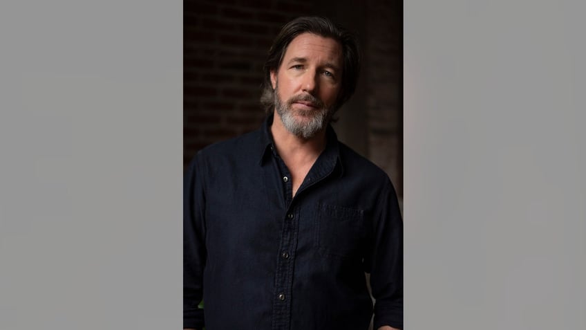 Ed Burns wearing a dark shirt.