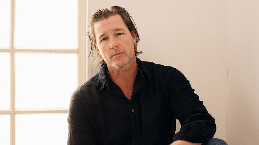 Ed Burns wearing a dark shirt.