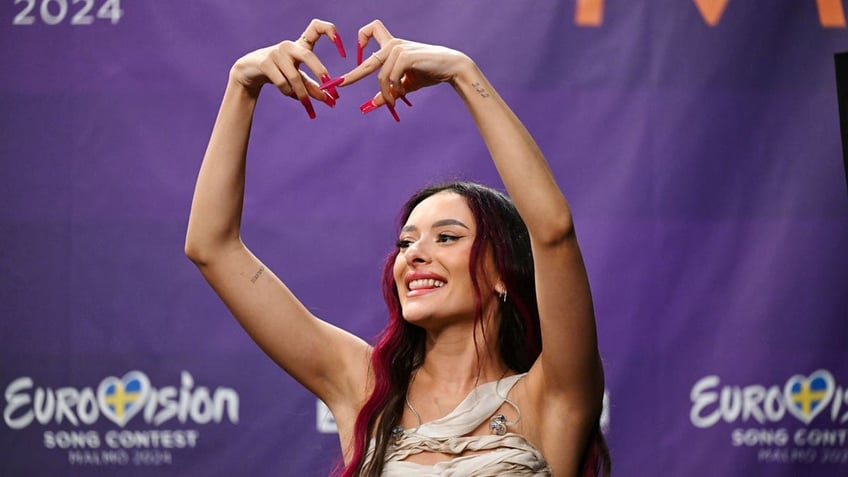 Eden Golan, representing Israel, makes a heart with her fingers during a press meeting with the entries that advanced to the final after the second semi-final of Eurovision 2024.