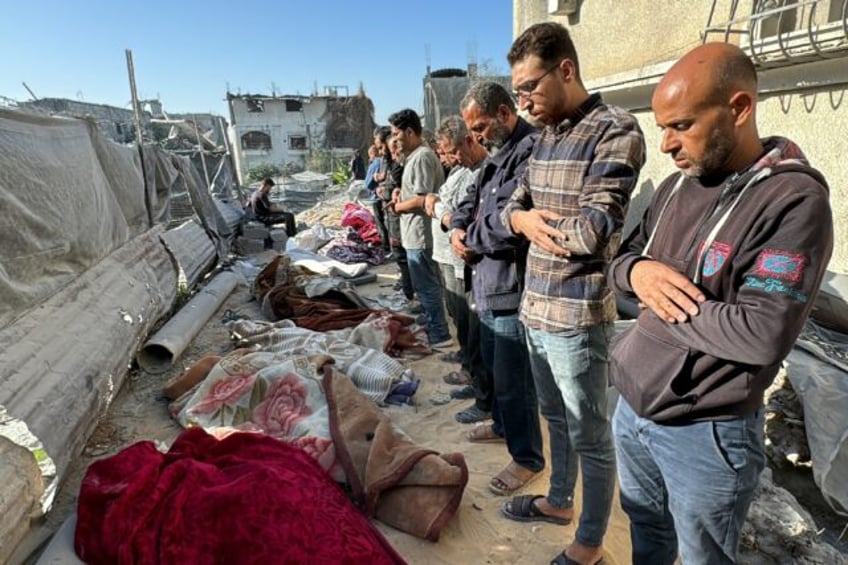 Palestinians pray over bodies of relatives, killed in an overnight Israeli airstrike in Be