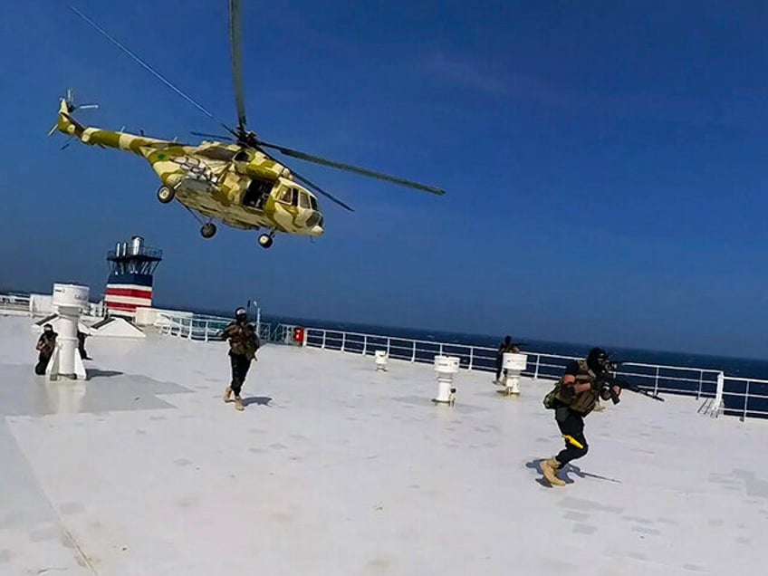 This photo released by the Houthi Media Center shows Houthi forces boarding the cargo ship