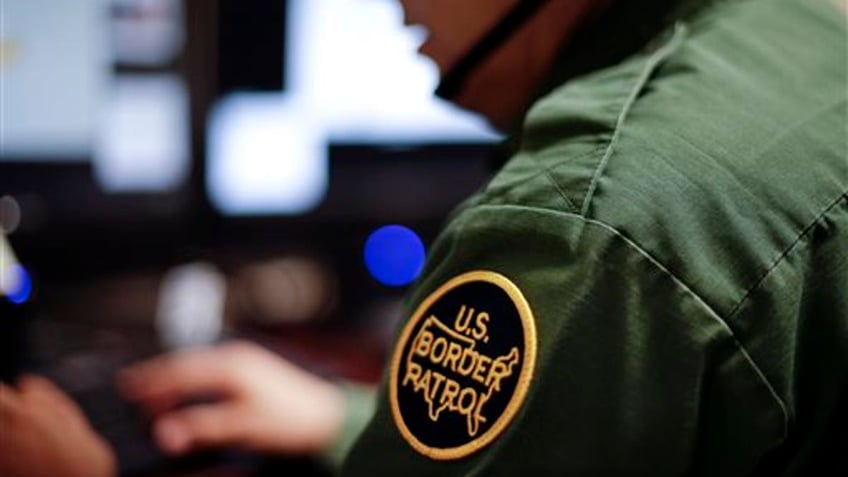 In this June 5, 2014 photo, a Border Patrol agent uses a headset and computer to conduct a long distance interview by video with a person arrested crossing the border in Texas, from a facility in San Diego. Hit with a dramatic increase of Central Americans crossing in South Texas, the Border Patrol is relieving staffing woes by enlisting agents in less busy sectors to process arrests through video interviews. (AP Photo/Gregory Bull)