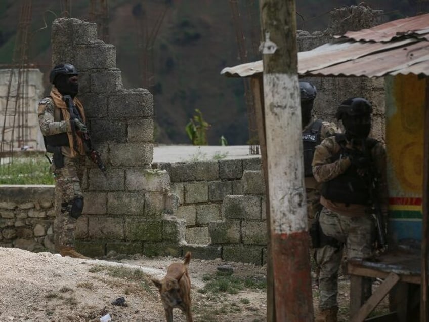 Police officers stand guard during an anti-gang operation in the Kenscoff neighborhood of