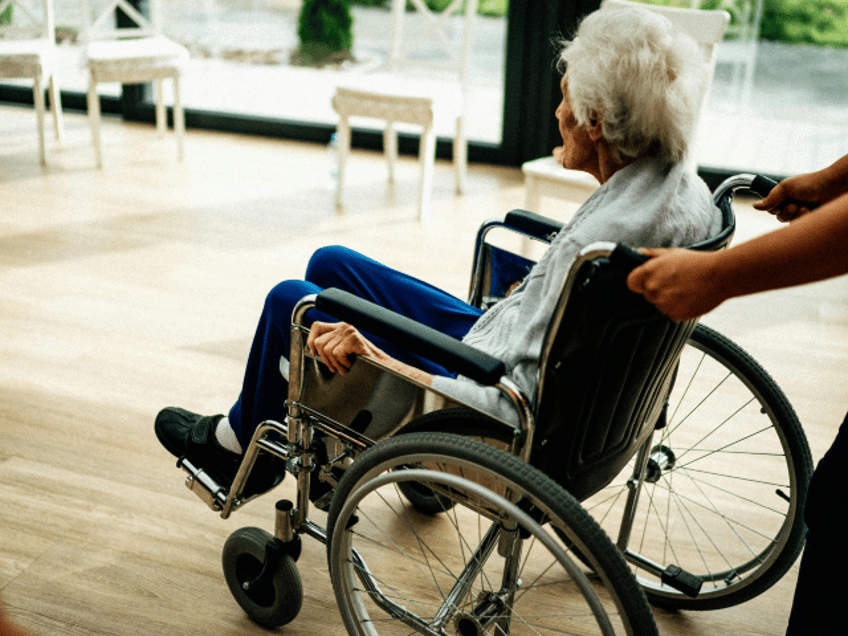 senior sitting in a wheelchair in a nursing home