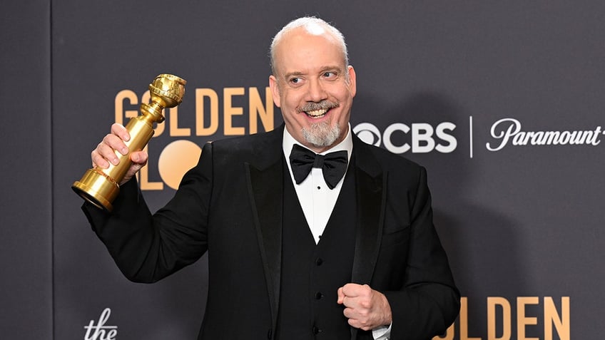 Paul Giamatti holds up his Golden Globe