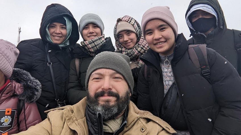 Bryan Stern and people rescued by Project Dynamo from Ukraine pose for a group selfie