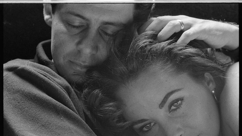 Eddie Fisher caressing Elizabeth Taylor in a close-up photo.