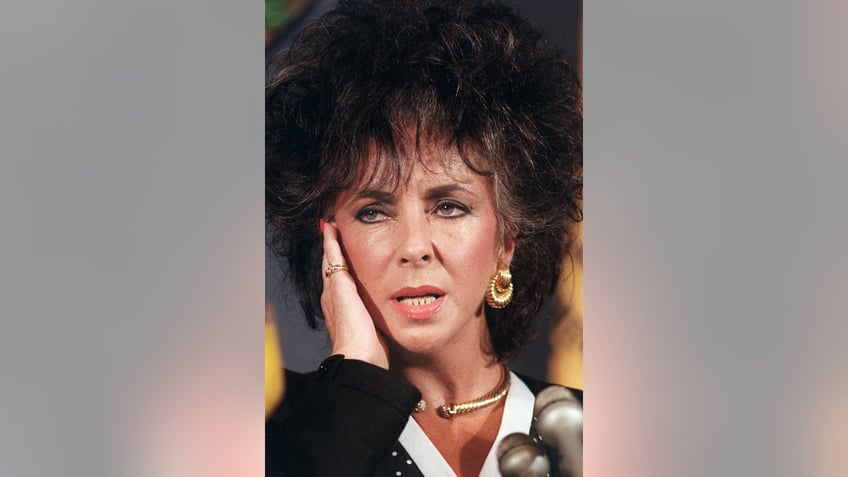 A close-up of Elizabeth Taylor touching her hand.