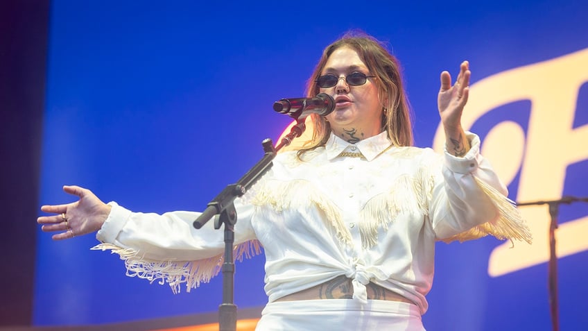 Elle King performing on stage at a microphone