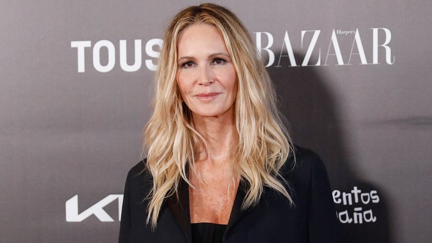 Elle Macpherson on the carpet in a black suit and shirt