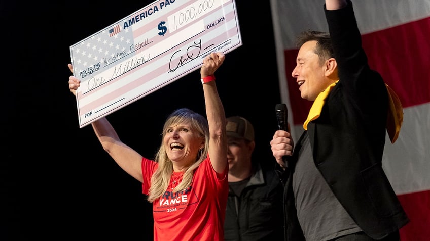 Elon Musk with woman holding giant $1 million check