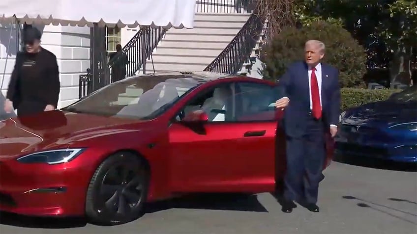 Trump is pictured with a Tesla