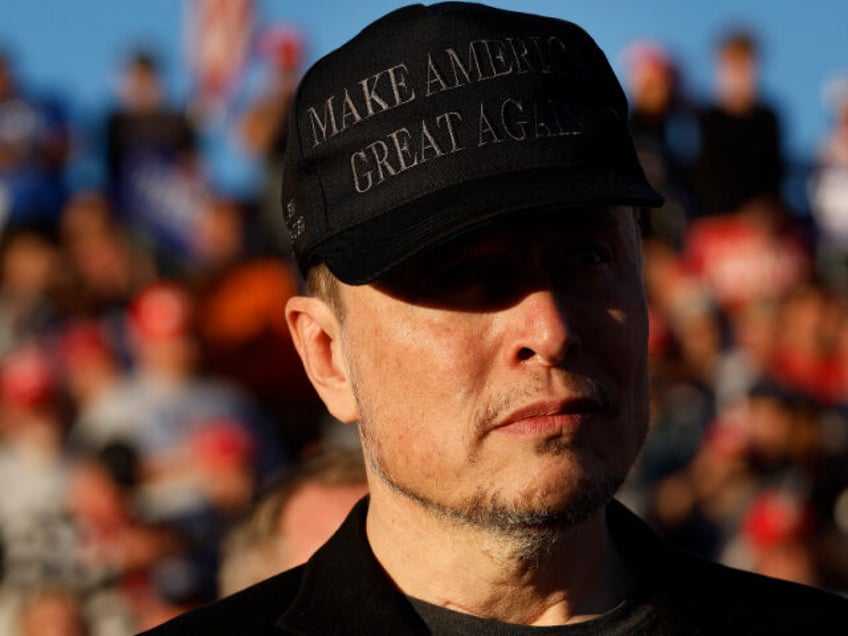 Elon Musk wears a black "Make America Great Again" ball cap while attending a ca
