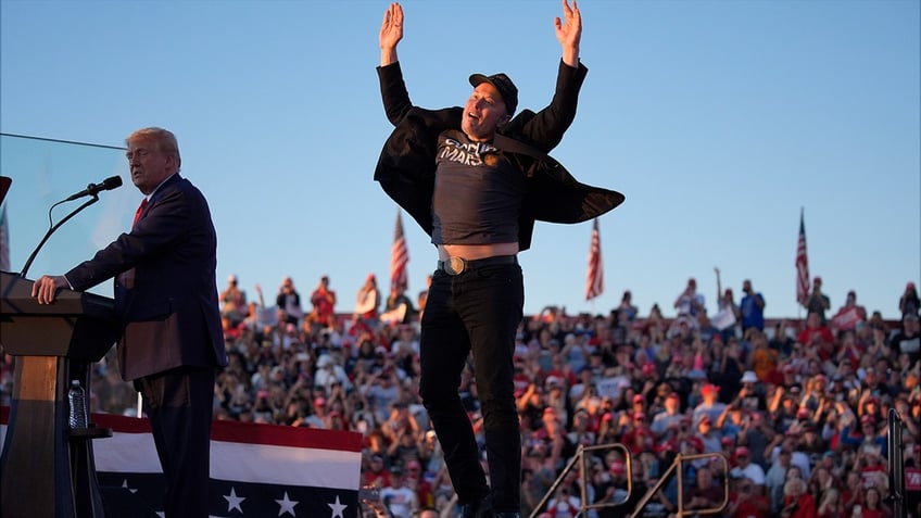 Elon Musk jumping in the air at a Trump rally