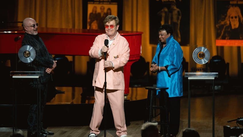 Elton John shares a laugh with Bernie Taupin, left, and Librarian of Congress Carla Hayden, right, during the 2024 Library of Congress Gershwin Prize for Popular Song tribute concert honoring John and Taupin at DAR Constitution Hall on Wednesday, March 20, 2024, in Washington. (AP Photo/Kevin Wolf)