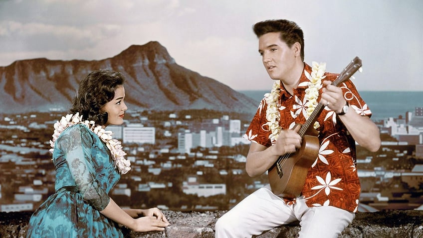 Elvis Presley playing a performing to a woman in Hawaii.