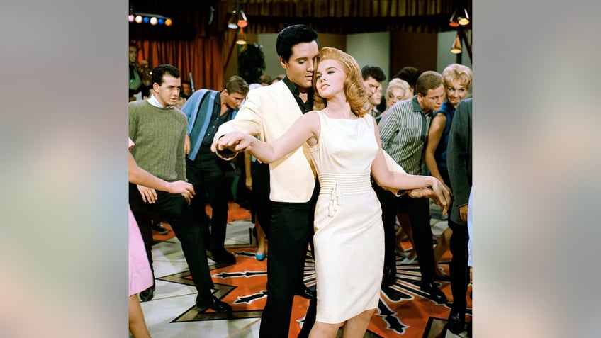 Elvis Presley holding Ann-Margret from behind on the dance floor.