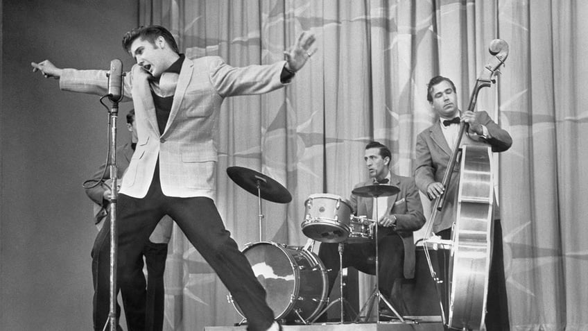 Black and white photo of Elvis Presley swinging his hips on television